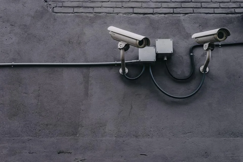 Caméras de vidéosurveillance fixées sur un mur, câblage sous gaine